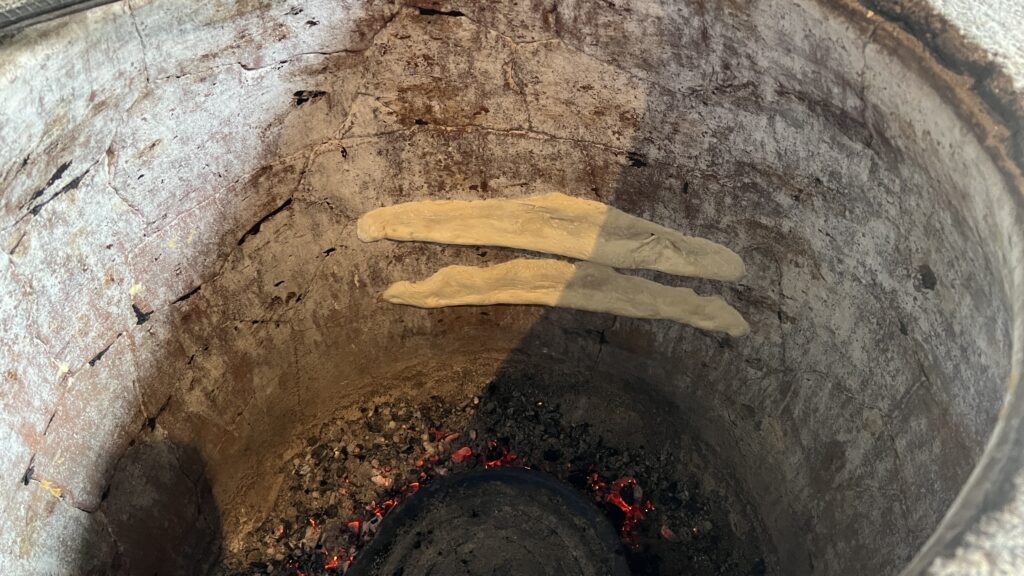 Georgisk puri brød, traditionelt georgisk brød bagt i lerovn, puri fra toneovn, hverdagsbrød i Georgien, madkultur i Georgien, nybagt georgisk puri, puri serveret til georgiske retter, blødt og luftigt georgisk brød, brød fra Kaukasus-regionen, autentisk georgisk puri bagt i vægmonteret ovn, georgisk madoplevelse med puri, brød med sprød skorpe og blød midte, puri som tilbehør til lobio og khinkali, Tea Tougaard oplever puribagning i Georgien, street food og bagerier i Georgien