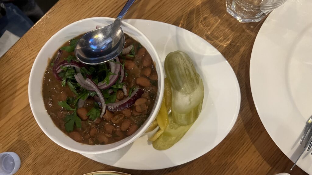 Lobio georgisk bønneret, traditionel mad fra Georgien, Lobio med røde bønner og krydderier, vegetarisk ret i det georgiske køkken, georgisk comfort food, Lobio med koriander og løg, krydret bønneret fra Kaukasus, georgisk vegetarret, madkultur i Georgien, klassisk Lobio i lerkrukke, Lobio serveret med majsbrød (mchadi), autentisk georgisk hverdagsret, Lobio opskrift fra Tbilisi, sund og mættende georgisk ret, Tea Tougaard oplever georgisk mad