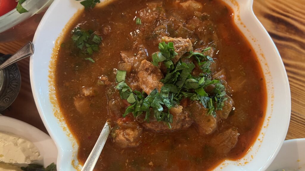 Ostri georgisk oksekødssauté, krydret kødstuvning fra Georgien, traditionel georgisk ret med tomat og hvidløg, simreret oksestuvning i georgisk stil, klassisk comfort food fra Tbilisi, georgisk Ostri med krydderurter og løg, kaukasisk køkken med stærk smag, simreret georgisk ret med paprika og chili, varme retter fra Georgien, Ostri i lergryde, autentisk georgisk mad, vinterret fra Georgien, Tea Tougaard smager Ostri i Georgien, madoplevelse med Ostri og georgisk vin, georgisk husmandskost med dyb smag