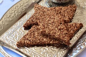 Pasteli, traditionel græsk snack lavet af honning og sesam, en af Grækenlands ældste søde specialiteter, naturlig energibar med kun få ingredienser, kendt for sin sprøde og karamelliserede tekstur, populær som både dessert og mellemmåltid, sundt alternativ i det græske køkken, græske desserter, græske kager