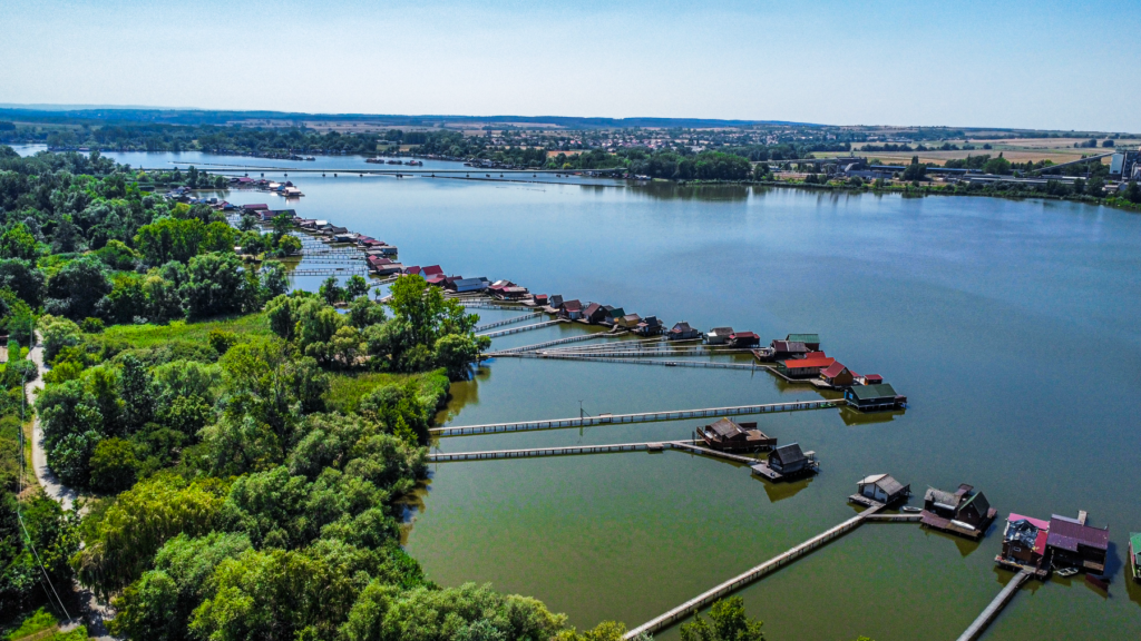 Bokod-reservoiret, Bokodi víztározó, skjult perle i Ungarn, svævende hytter på vandet, landskabsperle i Komárom-Esztergom-regionen, oplevelser i naturen i Ungarn, unikke søhuse i Bokod, fotospots i Ungarn, usædvanlige seværdigheder i Centraleuropa, fiskeri og ro i Ungarn, must-see i Ungarn, rejseoplevelser uden for alfarvej, arkitektur på søen, vinter og sommerstemning ved Bokod, miljø og natur i Ungarn, fredeligt udflugtsmål i Ungarn, skjulte steder at opleve i Ungarn.