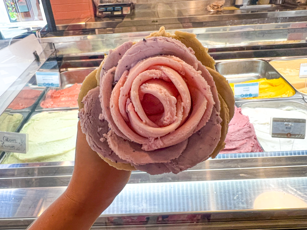 Rosenis i Budapest, is formet som en rose, gelato i Budapest, unikke isoplevelser i Budapest, søde oplevelser i Budapest, dessert i Budapest, berømte isbutikker i Budapest, smuk iskunst, håndlavet is i Budapest, fotovenlige desserter, street food i Budapest, must-try i Budapest, seværdigheder for madelskere, specialiteter i Budapest, turistattraktioner i Budapest, bedste is i Budapest.