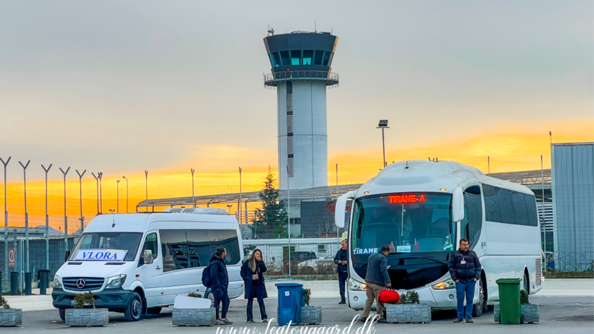 Guide til shuttlebus fra Tirana Lufthavn til Tirana centrum, transport fra Tirana International Airport, hvordan kommer man fra lufthavnen til byen, Rinas Express shuttlebus, offentlig transport i Tirana, praktisk rejsetips til Albanien, pris for shuttlebus Tirana, rejsetid mellem lufthavn og centrum, hvor finder man bussen i lufthavnen, komfortabel og billig transport i Tirana, shuttlebus tidsplan, bus til Skanderbeg-pladsen, hurtig transport til Tirana centrum, lufthavnstransfer i Albanien, ankomstinformation til Tirana, nem rejse fra lufthavn til hotel.