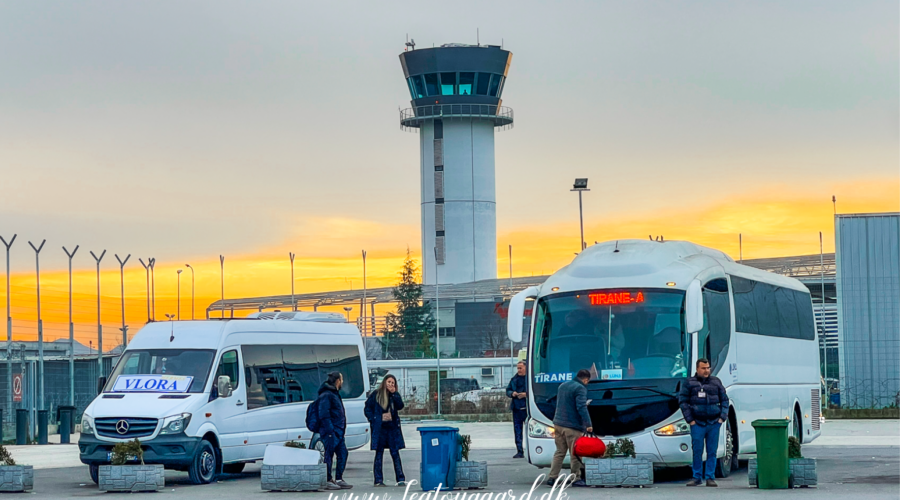 Guide til shuttlebus fra Tirana Lufthavn til Tirana centrum, transport fra Tirana International Airport, hvordan kommer man fra lufthavnen til byen, Rinas Express shuttlebus, offentlig transport i Tirana, praktisk rejsetips til Albanien, pris for shuttlebus Tirana, rejsetid mellem lufthavn og centrum, hvor finder man bussen i lufthavnen, komfortabel og billig transport i Tirana, shuttlebus tidsplan, bus til Skanderbeg-pladsen, hurtig transport til Tirana centrum, lufthavnstransfer i Albanien, ankomstinformation til Tirana, nem rejse fra lufthavn til hotel.