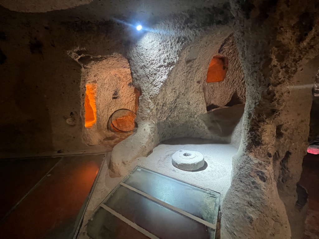 Kaymakli underjordiske by, underjordiske byer i Kappadokien, historiske seværdigheder i Tyrkiet, hulebyer i Anatolien, kristne tilflugtssteder under jorden, oplevelser i Cappadocia, tunneller og labyrinter i klippen, arkæologiske vidundere i Tyrkiet, Kaymakli byens otte niveauer, liv under jorden i oldtiden, stendøre og skjulte forsvarssystemer, must-see i det centrale Tyrkiet, anatolsk historie og kulturarv, underjordisk by med boliger, stalde og kirker, mystik og religion i Cappadocia, rejseoplevelser i Kaymakli.