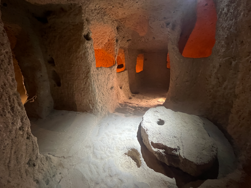 Kaymakli underjordiske by, underjordiske byer i Kappadokien, historiske seværdigheder i Tyrkiet, hulebyer i Anatolien, kristne tilflugtssteder under jorden, oplevelser i Cappadocia, tunneller og labyrinter i klippen, arkæologiske vidundere i Tyrkiet, Kaymakli byens otte niveauer, liv under jorden i oldtiden, stendøre og skjulte forsvarssystemer, must-see i det centrale Tyrkiet, anatolsk historie og kulturarv, underjordisk by med boliger, stalde og kirker, mystik og religion i Cappadocia, rejseoplevelser i Kaymakli.