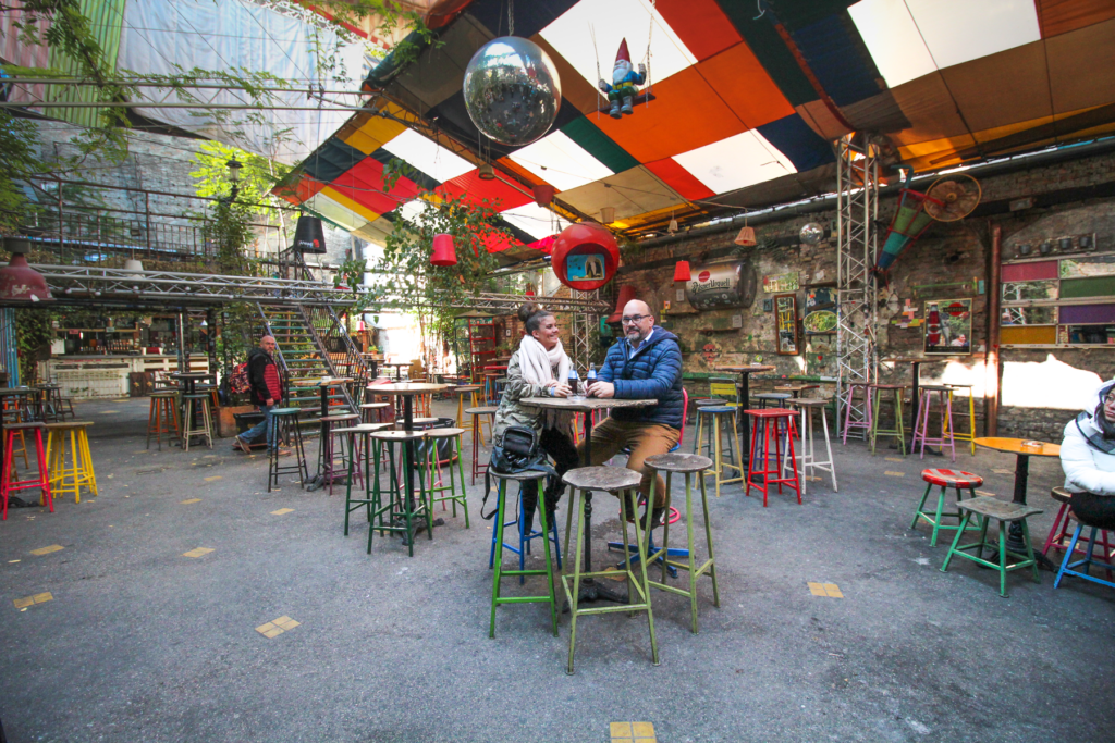 Ruinbarer i Budapest, Budapest ruinbarer, natteliv i Budapest, unikke barer i Budapest, Szimpla Kert, ruin pubs Budapest, oplevelser i Budapest, barer i Budapest, alternative barer i Budapest, fest i Budapest, seværdigheder i Budapest, historie om ruinbarer, ungarsk kultur, udendørs barer i Budapest, turistattraktioner i Budapest, stemningsfulde barer i Budapest.