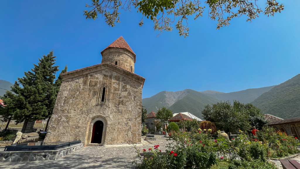 Kish Kirken i Azerbaijan, gammel stenbygget kirke i Kaukasus, historisk kirke i Kish landsbyen, kristen arv i Azerbaijan, Kaukasiens ældste kirke, religiøs seværdighed nær Shaki, albansk-kristen arkitektur, apostolsk historie i Kaukasus, must-see i det nordlige Azerbaijan, smukt restaureret kirke i grønne omgivelser, kulturarv fra det tidlige kristendom, Seværdigheder i Aserbajdsjan, oplevelser i Kaukasus, historiske steder i Aserbajdsjan, Kish kirken i Shaki-regionen,