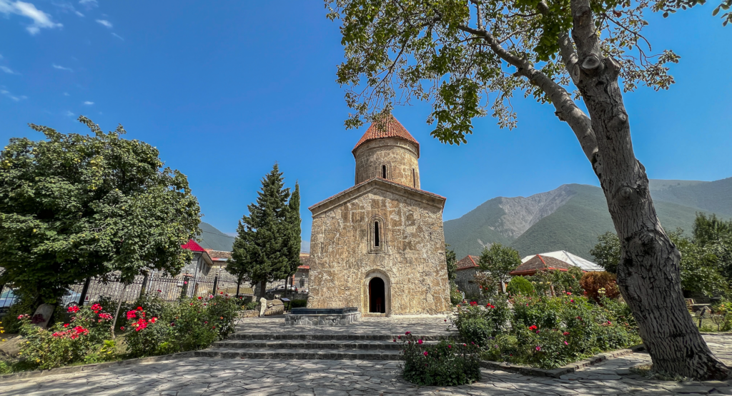 Kish Kirken i Azerbaijan, gammel stenbygget kirke i Kaukasus, historisk kirke i Kish landsbyen, kristen arv i Azerbaijan, Kaukasiens ældste kirke, religiøs seværdighed nær Shaki, albansk-kristen arkitektur, apostolsk historie i Kaukasus, must-see i det nordlige Azerbaijan, smukt restaureret kirke i grønne omgivelser, kulturarv fra det tidlige kristendom, Seværdigheder i Aserbajdsjan, oplevelser i Kaukasus, historiske steder i Aserbajdsjan, Kish kirken i Shaki-regionen,