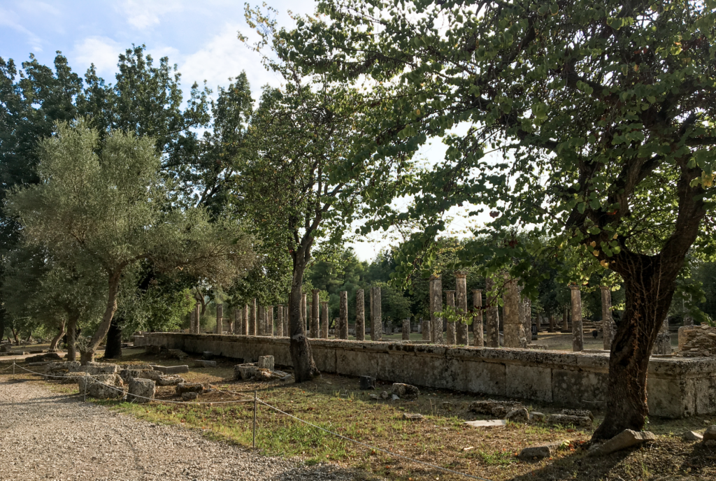 Gymnasion og Palaistra i Olympia, antikkens Grækenland, træningsområder for atleter, historiske bygninger i det olympiske område, græske sportsanlæg fra oldtiden, Gymnasion til løb og kastediscipliner, Palaistra til brydning og boksekampe, arkæologiske seværdigheder i Olympia, oplevelser i klassisk græsk sportskultur, ruiner i Peloponnes, fysisk træning og filosofi i oldtidens Grækenland, must-see for historie- og sportinteresserede.