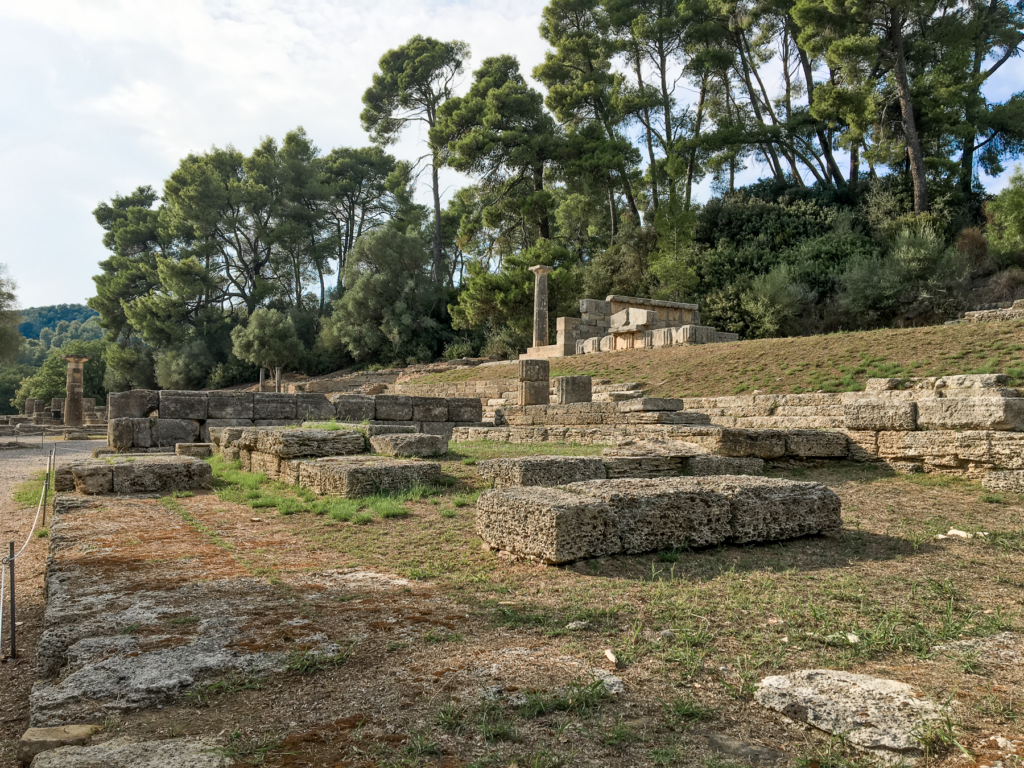 Metroon i Olympia, seværdighed i antikkens Grækenland, tempel dedikeret til modergudinden Rhea, beliggende i det historiske Olympia, arkæologisk seværdighed i Peloponnes, del af det olympiske hellige område, klassisk græsk tempelarkitektur, religiøst og kulturelt centrum i oldtiden, ruiner og rester af et vigtigt kultsted, oplevelse for historie- og arkæologiinteresserede, must-see under besøg i Olympia.