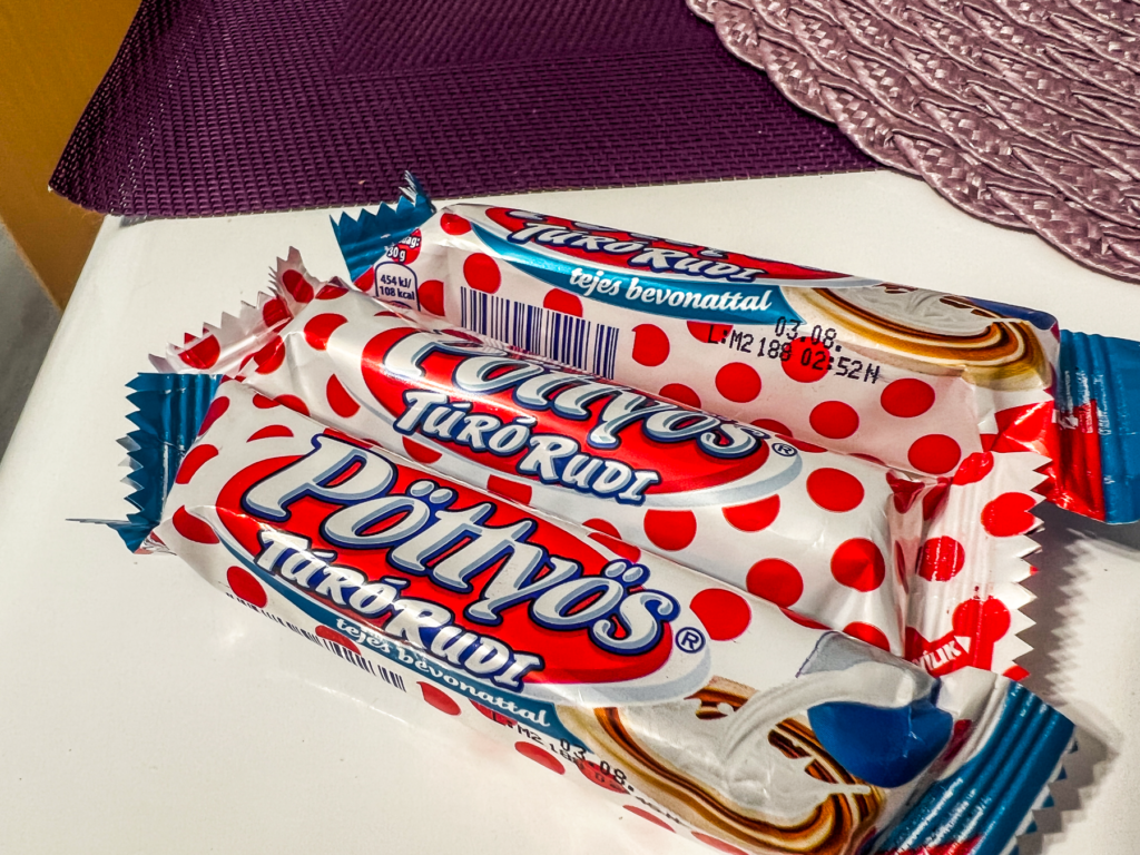 Ungarsk mad, snack du skal smage i Ungarn, Pöttyös Túró Rudi, ungarsk oste-chokoladebar, klassisk sød snack med vaniljeagtig ostemasse og chokoladeovertræk, ikonisk del af ungarsk madkultur, populær blandt både børn og voksne, madguide til Ungarn, unikt ungarsk slik