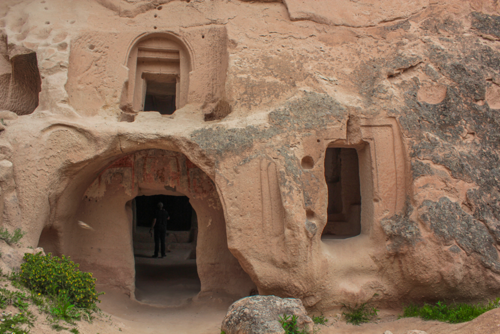 Balıklı ve Üzümlü Kirke i Zelve-dalen, historisk hulekirke i Kappadokien, kirke hugget i klippe, kristen arv i Anatolien, byzantinsk kirkerum med symboler af fisk (balık) og druer (üzüm), navngivet efter fresker og dekorationer i loft og vægge, religiøse motiver fra tidlig kristendom, skjult kirke i Zelve Open Air Museum, seværdigheder i Cappadocia, fredfyldt kirkerum i vulkansk landskab, oplevelser for historie- og kulturinteresserede, hulekirker og klippeliv i Tyrkiet, unikt stop på vandretur gennem Zelve-dalen.