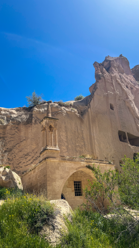 Klippe-moskéen i Zelve, historisk moské hugget i klippen, religiøs arv i Zelve-dalen, islamisk tilstedeværelse i Kappadokien, unikt eksempel på klippearkitektur brugt som moské, fredelig sameksistens mellem kristne og muslimer i Anatolien, seværdighed i Zelve Open Air Museum, enkel bønnesal i det vulkanske landskab, spor af hverdagsliv og tro i hulerne, islamisk kultur i Cappadocia, moskéens niche (mihrab) hugget direkte i sten, anatolsk historie med religiøs mangfoldighed, stemningsfuldt sted i det centrale Tyrkiet.