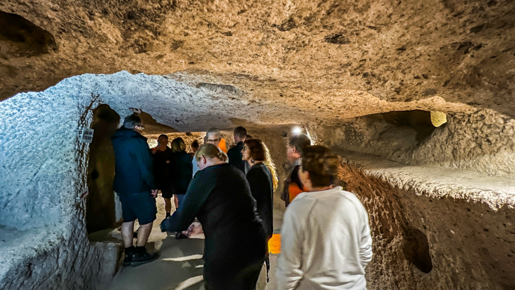 Kaymakli underjordiske by, underjordiske byer i Kappadokien, historiske seværdigheder i Tyrkiet, hulebyer i Anatolien, kristne tilflugtssteder under jorden, oplevelser i Cappadocia, tunneller og labyrinter i klippen, arkæologiske vidundere i Tyrkiet, Kaymakli byens otte niveauer, liv under jorden i oldtiden, stendøre og skjulte forsvarssystemer, must-see i det centrale Tyrkiet, anatolsk historie og kulturarv, underjordisk by med boliger, stalde og kirker, mystik og religion i Cappadocia, rejseoplevelser i Kaymakli