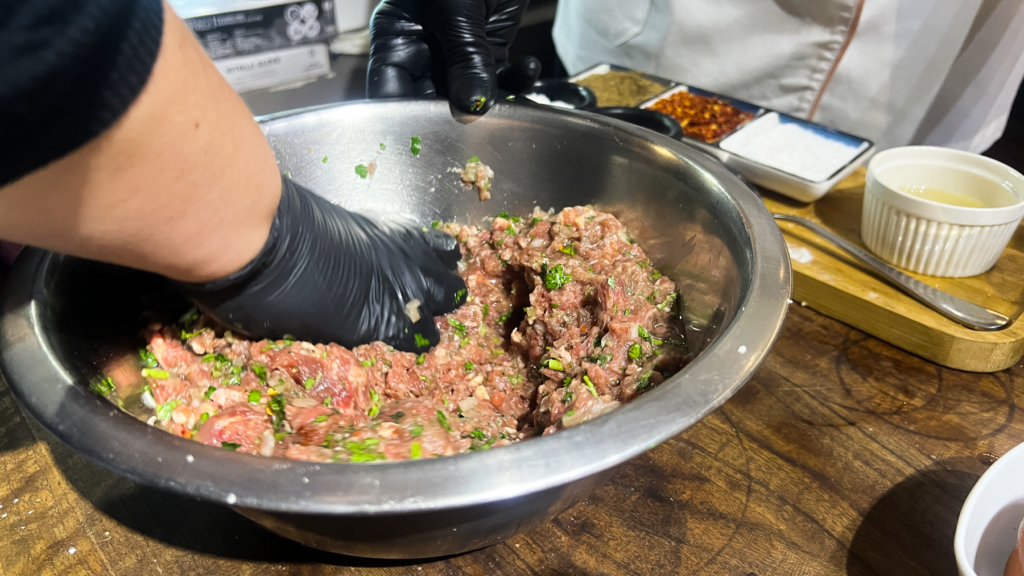 Opskrift på Klassisk Georgisk Dumpling – Khinkali Når man rejser i Georgien, er der én ret, man næsten ikke kan undgå at støde på – de ikoniske Khinkali. Den georgisk delikatesse, Khinkali, er en vidunderlig dumpling, der kombinerer en saftig kødfyldning med en smagfuld bouillon. De er både en kulinarisk oplevelse og en vigtig del af den georgiske madkultur. Jeg smagte dem første gang under min første rejse til Georgien og siden har jeg spist utallige af dem, med alle former for fyld. Med tiden blev min kærlighed til de georgiske khinkalis så stor, at jeg Her deler jeg min opskrift på de klassiske Khinkali, så du selv kan prøve kræfter med at lave dem derhjemme – og få en bid af Georgien i dit eget køkken. Ingredienser Dej • 12 dl mel • 3 dl lunkent vand • 1 teskefuld salt Du kan også bruge færdige dumpling-dejplader Fyld • 500 g hakket kød (okse, lam, svin eller en blanding) • 1 stort løg (finthakket) • 2 tsk chiliflager eller pulver • 2 tsk salt • 2 tsk peber • 2 tsk spidskommen • 2 tsk koriander Fremgangsmåde Forbered dejen: Hæld vand og salt i melet og ælt det godt. Dejen skal være fast. Dæk dejen og stil den i køleskabet i 2 timer. Ælt den derefter igen og lad den hvile yderligere 1 time. Tag dejen ud, rul den ud til ca. 1 cm tykkelse, og skær den i 20 portioner. Rul hver portion ud til en cirkel på 13-15 cm i diameter. Lav fyldet: Bland det hakkede kød med løg, krydderier og en smule vand for at skabe en saftig fyldning. Fyld og form dumplings: Læg en stor skefuld fyld i midten af hver dejcirkel. Saml kanterne og fold dem omhyggeligt for at lave små "folder", indtil dumplingen er lukket i en rørform. Drej og fjern overskydende dej for at forsegle toppen, så den ikke åbner sig når de koges. Kogning: Når alle khinkalis er samlet, så bringes en stor gryde med saltet vand i kog. Drop khinkalierne/dumplingsene forsigtigt i vandet og rør rundt for at undgå, at de klistrer sammen. Kog dem i ca. 7 minutter, indtil de flyder op til toppen af vandet. Så snart de er taget op ad det kogende vand er de klar til servering. Hvordan man spiser Khinkali Ligesom der er en helt speciel teknik til hvordan man laver khinkali, så er der også en helt bestemt teknik til hvordan man spiser de georgiske dumplings. For at spise khinkali på georgisk manér gør du følgende: • Hold dumplingen i den øverste foldede del og vend den på hoveder, så den ligner en svamp. • Tag en lille bid af siden og sug bouillonen ud. Husk at suge væsken ud så snart du har taget en bid, eller løber væsken ud over det hele. • Spis resten, men lad den øverste "knude" ligge – den anses for at være et "håndtag" og spises normalt ikke, selvom man godt kan. Georgisk opskrift, opskrifter på Georgisk mad, georgisk hovedret, georgiske madguide, madguide fra Georgien, georgisk mad du skal smage, georgisk mad, mad fra Georgien, madguide fra Georgien, georgisk mad du skal smage, Khinkali, traditionel georgisk dumpling, nationalret i Georgien, saftige dumplings med krydret kød, Khinkali fra Tbilisi, georgisk madkultur, håndlavede dumplings med bouillonfyld, oplevelser i georgisk køkken, must-try ret i Georgien, georgisk comfort food, Khinkali spises med hænder,