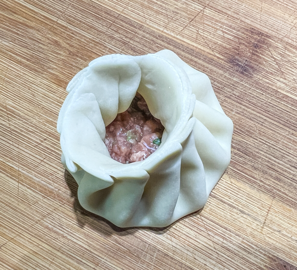 Opskrift på Klassisk Georgisk Dumpling – Khinkali Når man rejser i Georgien, er der én ret, man næsten ikke kan undgå at støde på – de ikoniske Khinkali. Den georgisk delikatesse, Khinkali, er en vidunderlig dumpling, der kombinerer en saftig kødfyldning med en smagfuld bouillon. De er både en kulinarisk oplevelse og en vigtig del af den georgiske madkultur. Jeg smagte dem første gang under min første rejse til Georgien og siden har jeg spist utallige af dem, med alle former for fyld. Med tiden blev min kærlighed til de georgiske khinkalis så stor, at jeg Her deler jeg min opskrift på de klassiske Khinkali, så du selv kan prøve kræfter med at lave dem derhjemme – og få en bid af Georgien i dit eget køkken. Ingredienser Dej • 12 dl mel • 3 dl lunkent vand • 1 teskefuld salt Du kan også bruge færdige dumpling-dejplader Fyld • 500 g hakket kød (okse, lam, svin eller en blanding) • 1 stort løg (finthakket) • 2 tsk chiliflager eller pulver • 2 tsk salt • 2 tsk peber • 2 tsk spidskommen • 2 tsk koriander Fremgangsmåde Forbered dejen: Hæld vand og salt i melet og ælt det godt. Dejen skal være fast. Dæk dejen og stil den i køleskabet i 2 timer. Ælt den derefter igen og lad den hvile yderligere 1 time. Tag dejen ud, rul den ud til ca. 1 cm tykkelse, og skær den i 20 portioner. Rul hver portion ud til en cirkel på 13-15 cm i diameter. Lav fyldet: Bland det hakkede kød med løg, krydderier og en smule vand for at skabe en saftig fyldning. Fyld og form dumplings: Læg en stor skefuld fyld i midten af hver dejcirkel. Saml kanterne og fold dem omhyggeligt for at lave små "folder", indtil dumplingen er lukket i en rørform. Drej og fjern overskydende dej for at forsegle toppen, så den ikke åbner sig når de koges. Kogning: Når alle khinkalis er samlet, så bringes en stor gryde med saltet vand i kog. Drop khinkalierne/dumplingsene forsigtigt i vandet og rør rundt for at undgå, at de klistrer sammen. Kog dem i ca. 7 minutter, indtil de flyder op til toppen af vandet. Så snart de er taget op ad det kogende vand er de klar til servering. Hvordan man spiser Khinkali Ligesom der er en helt speciel teknik til hvordan man laver khinkali, så er der også en helt bestemt teknik til hvordan man spiser de georgiske dumplings. For at spise khinkali på georgisk manér gør du følgende: • Hold dumplingen i den øverste foldede del og vend den på hoveder, så den ligner en svamp. • Tag en lille bid af siden og sug bouillonen ud. Husk at suge væsken ud så snart du har taget en bid, eller løber væsken ud over det hele. • Spis resten, men lad den øverste "knude" ligge – den anses for at være et "håndtag" og spises normalt ikke, selvom man godt kan. Georgisk opskrift, opskrifter på Georgisk mad, georgisk hovedret, georgiske madguide, madguide fra Georgien, georgisk mad du skal smage, georgisk mad, mad fra Georgien, madguide fra Georgien, georgisk mad du skal smage, Khinkali, traditionel georgisk dumpling, nationalret i Georgien, saftige dumplings med krydret kød, Khinkali fra Tbilisi, georgisk madkultur, håndlavede dumplings med bouillonfyld, oplevelser i georgisk køkken, must-try ret i Georgien, georgisk comfort food, Khinkali spises med hænder,