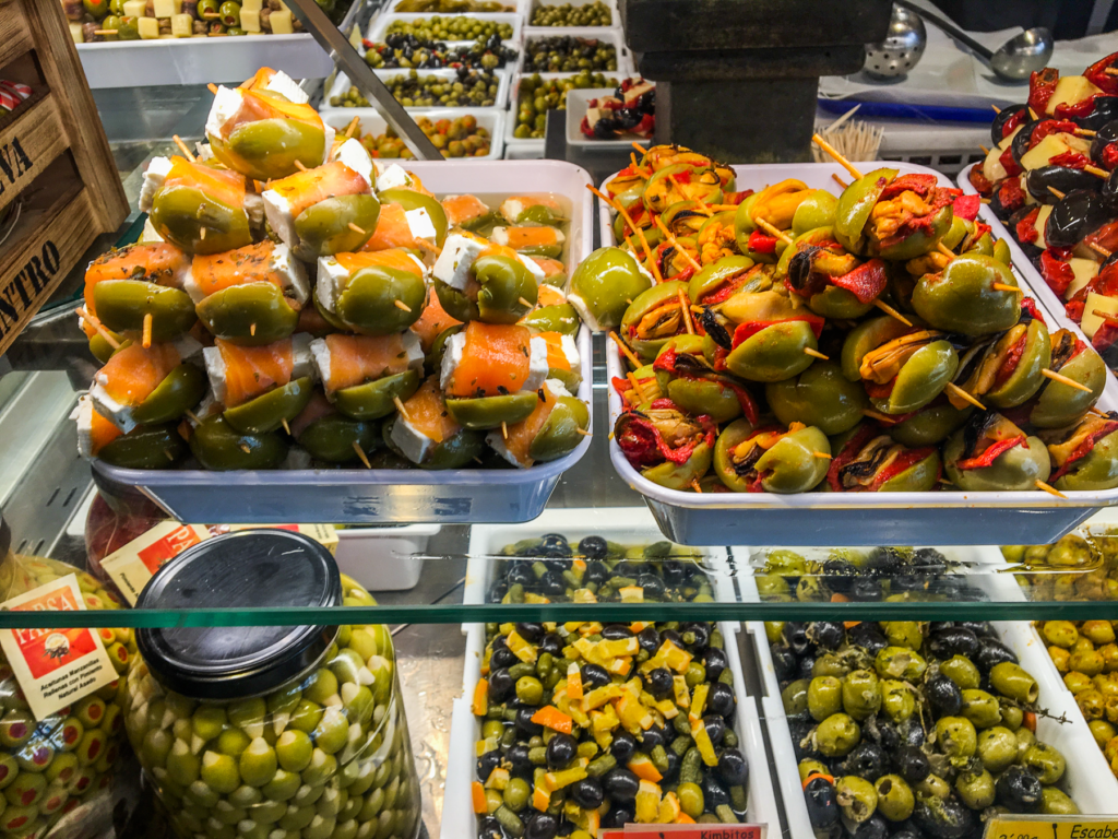 Mercado de San Miguel, Madrids bedste tapasmarked, gourmetmarked i Madrid centrum, spansk madmarked med tapas og specialiteter, seværdighed i Madrid, tapas og vin i smukke historiske omgivelser, markedsoplevelser i Spanien, spanske oste, skinke og skaldyr, must-visit for madelskere i Madrid, Mercado de San Miguel oplevelser, foodie guide Madrid, Seværdigheder i Madrid, oplevelser i Spaniens hovedstad, Madrid rejseguide,