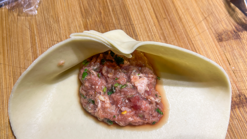 Opskrift på Klassisk Georgisk Dumpling – Khinkali Når man rejser i Georgien, er der én ret, man næsten ikke kan undgå at støde på – de ikoniske Khinkali. Den georgisk delikatesse, Khinkali, er en vidunderlig dumpling, der kombinerer en saftig kødfyldning med en smagfuld bouillon. De er både en kulinarisk oplevelse og en vigtig del af den georgiske madkultur. Jeg smagte dem første gang under min første rejse til Georgien og siden har jeg spist utallige af dem, med alle former for fyld. Med tiden blev min kærlighed til de georgiske khinkalis så stor, at jeg Her deler jeg min opskrift på de klassiske Khinkali, så du selv kan prøve kræfter med at lave dem derhjemme – og få en bid af Georgien i dit eget køkken. Ingredienser Dej • 12 dl mel • 3 dl lunkent vand • 1 teskefuld salt Du kan også bruge færdige dumpling-dejplader Fyld • 500 g hakket kød (okse, lam, svin eller en blanding) • 1 stort løg (finthakket) • 2 tsk chiliflager eller pulver • 2 tsk salt • 2 tsk peber • 2 tsk spidskommen • 2 tsk koriander Fremgangsmåde Forbered dejen: Hæld vand og salt i melet og ælt det godt. Dejen skal være fast. Dæk dejen og stil den i køleskabet i 2 timer. Ælt den derefter igen og lad den hvile yderligere 1 time. Tag dejen ud, rul den ud til ca. 1 cm tykkelse, og skær den i 20 portioner. Rul hver portion ud til en cirkel på 13-15 cm i diameter. Lav fyldet: Bland det hakkede kød med løg, krydderier og en smule vand for at skabe en saftig fyldning. Fyld og form dumplings: Læg en stor skefuld fyld i midten af hver dejcirkel. Saml kanterne og fold dem omhyggeligt for at lave små "folder", indtil dumplingen er lukket i en rørform. Drej og fjern overskydende dej for at forsegle toppen, så den ikke åbner sig når de koges. Kogning: Når alle khinkalis er samlet, så bringes en stor gryde med saltet vand i kog. Drop khinkalierne/dumplingsene forsigtigt i vandet og rør rundt for at undgå, at de klistrer sammen. Kog dem i ca. 7 minutter, indtil de flyder op til toppen af vandet. Så snart de er taget op ad det kogende vand er de klar til servering. Hvordan man spiser Khinkali Ligesom der er en helt speciel teknik til hvordan man laver khinkali, så er der også en helt bestemt teknik til hvordan man spiser de georgiske dumplings. For at spise khinkali på georgisk manér gør du følgende: • Hold dumplingen i den øverste foldede del og vend den på hoveder, så den ligner en svamp. • Tag en lille bid af siden og sug bouillonen ud. Husk at suge væsken ud så snart du har taget en bid, eller løber væsken ud over det hele. • Spis resten, men lad den øverste "knude" ligge – den anses for at være et "håndtag" og spises normalt ikke, selvom man godt kan. Georgisk opskrift, opskrifter på Georgisk mad, georgisk hovedret, georgiske madguide, madguide fra Georgien, georgisk mad du skal smage, georgisk mad, mad fra Georgien, madguide fra Georgien, georgisk mad du skal smage, Khinkali, traditionel georgisk dumpling, nationalret i Georgien, saftige dumplings med krydret kød, Khinkali fra Tbilisi, georgisk madkultur, håndlavede dumplings med bouillonfyld, oplevelser i georgisk køkken, must-try ret i Georgien, georgisk comfort food, Khinkali spises med hænder,