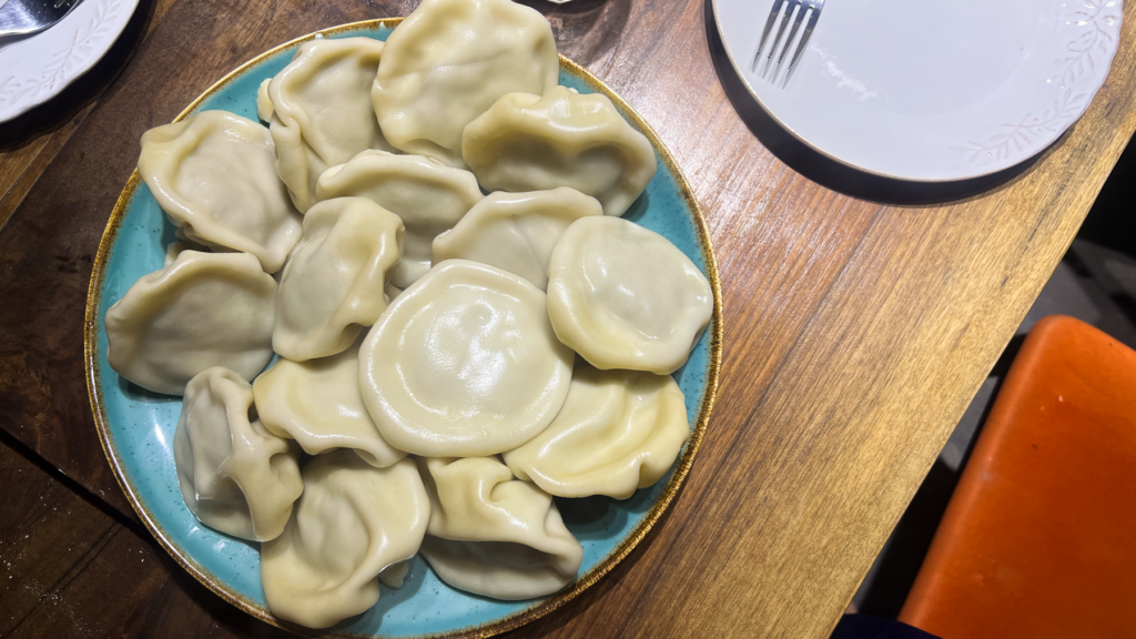 Opskrift på Klassisk Georgisk Dumpling – Khinkali Når man rejser i Georgien, er der én ret, man næsten ikke kan undgå at støde på – de ikoniske Khinkali. Den georgisk delikatesse, Khinkali, er en vidunderlig dumpling, der kombinerer en saftig kødfyldning med en smagfuld bouillon. De er både en kulinarisk oplevelse og en vigtig del af den georgiske madkultur. Jeg smagte dem første gang under min første rejse til Georgien og siden har jeg spist utallige af dem, med alle former for fyld. Med tiden blev min kærlighed til de georgiske khinkalis så stor, at jeg Her deler jeg min opskrift på de klassiske Khinkali, så du selv kan prøve kræfter med at lave dem derhjemme – og få en bid af Georgien i dit eget køkken. Ingredienser Dej • 12 dl mel • 3 dl lunkent vand • 1 teskefuld salt Du kan også bruge færdige dumpling-dejplader Fyld • 500 g hakket kød (okse, lam, svin eller en blanding) • 1 stort løg (finthakket) • 2 tsk chiliflager eller pulver • 2 tsk salt • 2 tsk peber • 2 tsk spidskommen • 2 tsk koriander Fremgangsmåde Forbered dejen: Hæld vand og salt i melet og ælt det godt. Dejen skal være fast. Dæk dejen og stil den i køleskabet i 2 timer. Ælt den derefter igen og lad den hvile yderligere 1 time. Tag dejen ud, rul den ud til ca. 1 cm tykkelse, og skær den i 20 portioner. Rul hver portion ud til en cirkel på 13-15 cm i diameter. Lav fyldet: Bland det hakkede kød med løg, krydderier og en smule vand for at skabe en saftig fyldning. Fyld og form dumplings: Læg en stor skefuld fyld i midten af hver dejcirkel. Saml kanterne og fold dem omhyggeligt for at lave små "folder", indtil dumplingen er lukket i en rørform. Drej og fjern overskydende dej for at forsegle toppen, så den ikke åbner sig når de koges. Kogning: Når alle khinkalis er samlet, så bringes en stor gryde med saltet vand i kog. Drop khinkalierne/dumplingsene forsigtigt i vandet og rør rundt for at undgå, at de klistrer sammen. Kog dem i ca. 7 minutter, indtil de flyder op til toppen af vandet. Så snart de er taget op ad det kogende vand er de klar til servering. Hvordan man spiser Khinkali Ligesom der er en helt speciel teknik til hvordan man laver khinkali, så er der også en helt bestemt teknik til hvordan man spiser de georgiske dumplings. For at spise khinkali på georgisk manér gør du følgende: • Hold dumplingen i den øverste foldede del og vend den på hoveder, så den ligner en svamp. • Tag en lille bid af siden og sug bouillonen ud. Husk at suge væsken ud så snart du har taget en bid, eller løber væsken ud over det hele. • Spis resten, men lad den øverste "knude" ligge – den anses for at være et "håndtag" og spises normalt ikke, selvom man godt kan. Georgisk opskrift, opskrifter på Georgisk mad, georgisk hovedret, georgiske madguide, madguide fra Georgien, georgisk mad du skal smage, georgisk mad, mad fra Georgien, madguide fra Georgien, georgisk mad du skal smage, Khinkali, traditionel georgisk dumpling, nationalret i Georgien, saftige dumplings med krydret kød, Khinkali fra Tbilisi, georgisk madkultur, håndlavede dumplings med bouillonfyld, oplevelser i georgisk køkken, must-try ret i Georgien, georgisk comfort food, Khinkali spises med hænder,