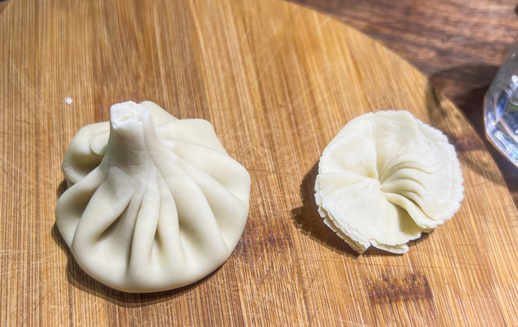 Opskrift på Klassisk Georgisk Dumpling – Khinkali Når man rejser i Georgien, er der én ret, man næsten ikke kan undgå at støde på – de ikoniske Khinkali. Den georgisk delikatesse, Khinkali, er en vidunderlig dumpling, der kombinerer en saftig kødfyldning med en smagfuld bouillon. De er både en kulinarisk oplevelse og en vigtig del af den georgiske madkultur. Jeg smagte dem første gang under min første rejse til Georgien og siden har jeg spist utallige af dem, med alle former for fyld. Med tiden blev min kærlighed til de georgiske khinkalis så stor, at jeg Her deler jeg min opskrift på de klassiske Khinkali, så du selv kan prøve kræfter med at lave dem derhjemme – og få en bid af Georgien i dit eget køkken. Ingredienser Dej • 12 dl mel • 3 dl lunkent vand • 1 teskefuld salt Du kan også bruge færdige dumpling-dejplader Fyld • 500 g hakket kød (okse, lam, svin eller en blanding) • 1 stort løg (finthakket) • 2 tsk chiliflager eller pulver • 2 tsk salt • 2 tsk peber • 2 tsk spidskommen • 2 tsk koriander Fremgangsmåde Forbered dejen: Hæld vand og salt i melet og ælt det godt. Dejen skal være fast. Dæk dejen og stil den i køleskabet i 2 timer. Ælt den derefter igen og lad den hvile yderligere 1 time. Tag dejen ud, rul den ud til ca. 1 cm tykkelse, og skær den i 20 portioner. Rul hver portion ud til en cirkel på 13-15 cm i diameter. Lav fyldet: Bland det hakkede kød med løg, krydderier og en smule vand for at skabe en saftig fyldning. Fyld og form dumplings: Læg en stor skefuld fyld i midten af hver dejcirkel. Saml kanterne og fold dem omhyggeligt for at lave små "folder", indtil dumplingen er lukket i en rørform. Drej og fjern overskydende dej for at forsegle toppen, så den ikke åbner sig når de koges. Kogning: Når alle khinkalis er samlet, så bringes en stor gryde med saltet vand i kog. Drop khinkalierne/dumplingsene forsigtigt i vandet og rør rundt for at undgå, at de klistrer sammen. Kog dem i ca. 7 minutter, indtil de flyder op til toppen af vandet. Så snart de er taget op ad det kogende vand er de klar til servering. Hvordan man spiser Khinkali Ligesom der er en helt speciel teknik til hvordan man laver khinkali, så er der også en helt bestemt teknik til hvordan man spiser de georgiske dumplings. For at spise khinkali på georgisk manér gør du følgende: • Hold dumplingen i den øverste foldede del og vend den på hoveder, så den ligner en svamp. • Tag en lille bid af siden og sug bouillonen ud. Husk at suge væsken ud så snart du har taget en bid, eller løber væsken ud over det hele. • Spis resten, men lad den øverste "knude" ligge – den anses for at være et "håndtag" og spises normalt ikke, selvom man godt kan. Georgisk opskrift, opskrifter på Georgisk mad, georgisk hovedret, georgiske madguide, madguide fra Georgien, georgisk mad du skal smage, georgisk mad, mad fra Georgien, madguide fra Georgien, georgisk mad du skal smage, Khinkali, traditionel georgisk dumpling, nationalret i Georgien, saftige dumplings med krydret kød, Khinkali fra Tbilisi, georgisk madkultur, håndlavede dumplings med bouillonfyld, oplevelser i georgisk køkken, must-try ret i Georgien, georgisk comfort food, Khinkali spises med hænder,