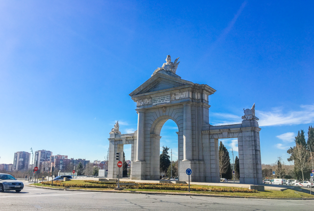 Puerta de Alcalá, majestætisk byport i Madrid, historisk vartegn i Spaniens hovedstad, neoklassisk port fra 1778, Carlos III monument, seværdighed i Retiro-området, ikonisk fotospot i Madrid, kultur og arkitektur i Spanien, oplevelser ved Plaza de la Independencia, must-see attraktion i Madrid, byport ved Retiro-parken, guide Madrid, Seværdigheder i Madrid, oplevelser i Spaniens hovedstad, Madrid rejseguide,