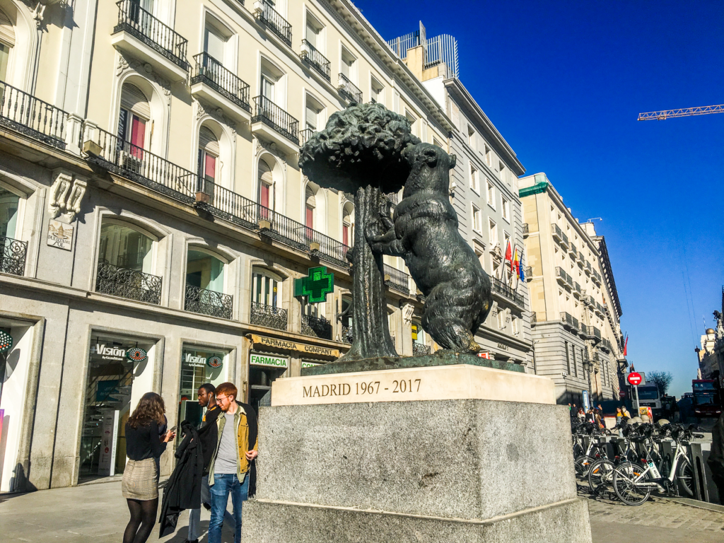 Puerta del Sol, kendt plads i Madrid, centrum af Spaniens hovedstad, kilometer nul for Spanien, ikoniske bygninger og urtårn, seværdighed i Madrid centrum, statuen El Oso y El Madroño, historisk og kulturelt centrum i Madrid, must-see oplevelse i Madrid, must-see i Madrid, historiske og kulturelle oplevelser i Madrid centrum, Seværdigheder i Madrid, oplevelser i Spaniens hovedstad, Madrid rejseguide,