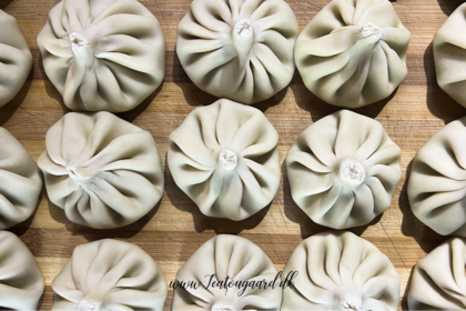 Opskrift på Klassisk Georgisk Dumpling – Khinkali Når man rejser i Georgien, er der én ret, man næsten ikke kan undgå at støde på – de ikoniske Khinkali. Den georgisk delikatesse, Khinkali, er en vidunderlig dumpling, der kombinerer en saftig kødfyldning med en smagfuld bouillon. De er både en kulinarisk oplevelse og en vigtig del af den georgiske madkultur. Jeg smagte dem første gang under min første rejse til Georgien og siden har jeg spist utallige af dem, med alle former for fyld. Med tiden blev min kærlighed til de georgiske khinkalis så stor, at jeg Her deler jeg min opskrift på de klassiske Khinkali, så du selv kan prøve kræfter med at lave dem derhjemme – og få en bid af Georgien i dit eget køkken. Ingredienser Dej • 12 dl mel • 3 dl lunkent vand • 1 teskefuld salt Du kan også bruge færdige dumpling-dejplader Fyld • 500 g hakket kød (okse, lam, svin eller en blanding) • 1 stort løg (finthakket) • 2 tsk chiliflager eller pulver • 2 tsk salt • 2 tsk peber • 2 tsk spidskommen • 2 tsk koriander Fremgangsmåde Forbered dejen: Hæld vand og salt i melet og ælt det godt. Dejen skal være fast. Dæk dejen og stil den i køleskabet i 2 timer. Ælt den derefter igen og lad den hvile yderligere 1 time. Tag dejen ud, rul den ud til ca. 1 cm tykkelse, og skær den i 20 portioner. Rul hver portion ud til en cirkel på 13-15 cm i diameter. Lav fyldet: Bland det hakkede kød med løg, krydderier og en smule vand for at skabe en saftig fyldning. Fyld og form dumplings: Læg en stor skefuld fyld i midten af hver dejcirkel. Saml kanterne og fold dem omhyggeligt for at lave små "folder", indtil dumplingen er lukket i en rørform. Drej og fjern overskydende dej for at forsegle toppen, så den ikke åbner sig når de koges. Kogning: Når alle khinkalis er samlet, så bringes en stor gryde med saltet vand i kog. Drop khinkalierne/dumplingsene forsigtigt i vandet og rør rundt for at undgå, at de klistrer sammen. Kog dem i ca. 7 minutter, indtil de flyder op til toppen af vandet. Så snart de er taget op ad det kogende vand er de klar til servering. Hvordan man spiser Khinkali Ligesom der er en helt speciel teknik til hvordan man laver khinkali, så er der også en helt bestemt teknik til hvordan man spiser de georgiske dumplings. For at spise khinkali på georgisk manér gør du følgende: • Hold dumplingen i den øverste foldede del og vend den på hoveder, så den ligner en svamp. • Tag en lille bid af siden og sug bouillonen ud. Husk at suge væsken ud så snart du har taget en bid, eller løber væsken ud over det hele. • Spis resten, men lad den øverste "knude" ligge – den anses for at være et "håndtag" og spises normalt ikke, selvom man godt kan. Georgisk opskrift, opskrifter på Georgisk mad, georgisk hovedret, georgiske madguide, madguide fra Georgien, georgisk mad du skal smage, georgisk mad, mad fra Georgien, madguide fra Georgien, georgisk mad du skal smage, Khinkali, traditionel georgisk dumpling, nationalret i Georgien, saftige dumplings med krydret kød, Khinkali fra Tbilisi, georgisk madkultur, håndlavede dumplings med bouillonfyld, oplevelser i georgisk køkken, must-try ret i Georgien, georgisk comfort food, Khinkali spises med hænder,