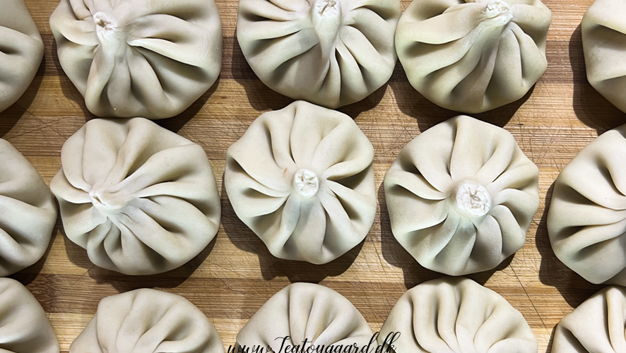 Opskrift på Klassisk Georgisk Dumpling – Khinkali Når man rejser i Georgien, er der én ret, man næsten ikke kan undgå at støde på – de ikoniske Khinkali. Den georgisk delikatesse, Khinkali, er en vidunderlig dumpling, der kombinerer en saftig kødfyldning med en smagfuld bouillon. De er både en kulinarisk oplevelse og en vigtig del af den georgiske madkultur. Jeg smagte dem første gang under min første rejse til Georgien og siden har jeg spist utallige af dem, med alle former for fyld. Med tiden blev min kærlighed til de georgiske khinkalis så stor, at jeg Her deler jeg min opskrift på de klassiske Khinkali, så du selv kan prøve kræfter med at lave dem derhjemme – og få en bid af Georgien i dit eget køkken. Ingredienser Dej • 12 dl mel • 3 dl lunkent vand • 1 teskefuld salt Du kan også bruge færdige dumpling-dejplader Fyld • 500 g hakket kød (okse, lam, svin eller en blanding) • 1 stort løg (finthakket) • 2 tsk chiliflager eller pulver • 2 tsk salt • 2 tsk peber • 2 tsk spidskommen • 2 tsk koriander Fremgangsmåde Forbered dejen: Hæld vand og salt i melet og ælt det godt. Dejen skal være fast. Dæk dejen og stil den i køleskabet i 2 timer. Ælt den derefter igen og lad den hvile yderligere 1 time. Tag dejen ud, rul den ud til ca. 1 cm tykkelse, og skær den i 20 portioner. Rul hver portion ud til en cirkel på 13-15 cm i diameter. Lav fyldet: Bland det hakkede kød med løg, krydderier og en smule vand for at skabe en saftig fyldning. Fyld og form dumplings: Læg en stor skefuld fyld i midten af hver dejcirkel. Saml kanterne og fold dem omhyggeligt for at lave små "folder", indtil dumplingen er lukket i en rørform. Drej og fjern overskydende dej for at forsegle toppen, så den ikke åbner sig når de koges. Kogning: Når alle khinkalis er samlet, så bringes en stor gryde med saltet vand i kog. Drop khinkalierne/dumplingsene forsigtigt i vandet og rør rundt for at undgå, at de klistrer sammen. Kog dem i ca. 7 minutter, indtil de flyder op til toppen af vandet. Så snart de er taget op ad det kogende vand er de klar til servering. Hvordan man spiser Khinkali Ligesom der er en helt speciel teknik til hvordan man laver khinkali, så er der også en helt bestemt teknik til hvordan man spiser de georgiske dumplings. For at spise khinkali på georgisk manér gør du følgende: • Hold dumplingen i den øverste foldede del og vend den på hoveder, så den ligner en svamp. • Tag en lille bid af siden og sug bouillonen ud. Husk at suge væsken ud så snart du har taget en bid, eller løber væsken ud over det hele. • Spis resten, men lad den øverste "knude" ligge – den anses for at være et "håndtag" og spises normalt ikke, selvom man godt kan. Georgisk opskrift, opskrifter på Georgisk mad, georgisk hovedret, georgiske madguide, madguide fra Georgien, georgisk mad du skal smage, georgisk mad, mad fra Georgien, madguide fra Georgien, georgisk mad du skal smage, Khinkali, traditionel georgisk dumpling, nationalret i Georgien, saftige dumplings med krydret kød, Khinkali fra Tbilisi, georgisk madkultur, håndlavede dumplings med bouillonfyld, oplevelser i georgisk køkken, must-try ret i Georgien, georgisk comfort food, Khinkali spises med hænder,
