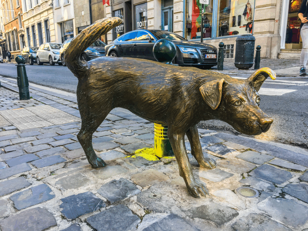 Zinneke Pis, tissende hund statue i Bruxelles, tredje figur i Pis-trilogien, humoristisk gadekunst i Belgien, moderne seværdighed i Bruxelles, symbol på byens mangfoldighed, Zinneke Pis statue i Belgien, tissende hund som kunstværk, quirky seværdigheder i Bruxelles, belgisk gadekunst, alternativ turistattraktion i Belgien, urban kunst i Bruxelles, skulptur af hund i centrum, sjove oplevelser i Bruxelles, Pis-familien i Belgien