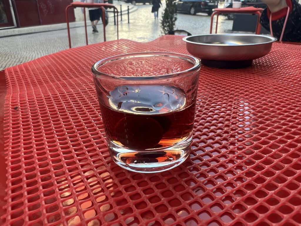 Ginjinha shots, portugisisk kirsebærlikør, drikkevarer fra Portugal, traditionelle portugisiske shots, Ginja de Lisboa, Ginjinha Espinheira, Ginjinha-servet i chokoladekop, likør fra Portugal, portugisiske specialiteter, must-try drikke i Portugal, typiske portugisiske drikkevarer, kirsebærshot fra Portugal, lokal portugisisk kultur, autentiske oplevelser i Lissabon, sød kirsebærlikør, shots i Portugal, portugisisk mad og drikke, drikke du skal smage i Portugal, portugisisk spiritus, street drinks i Lissabon, oplev ginjinha i Portugal