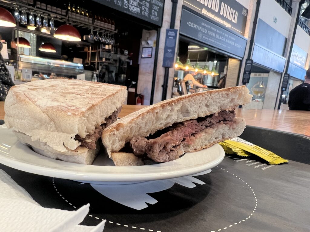 Prego sandwich, portugisisk bøfsandwich, traditionel streetfood fra Portugal, mad fra Portugal, portugisisk madguide, portugisiske specialiteter, mad du skal smage i Portugal, oksekødssandwich fra Portugal, must-try retter i Lissabon og Porto, portugisisk fastfood, klassisk portugisisk frokostret, portugisisk køkken, madoplevelser i Portugal, smag af Portugal, autentisk portugisisk mad, lokale retter fra Portugal, prego no pão, portugisisk gastronomi, bøf i bolle, portugisisk hverdagsmad, kulinarisk rejse gennem Portugal